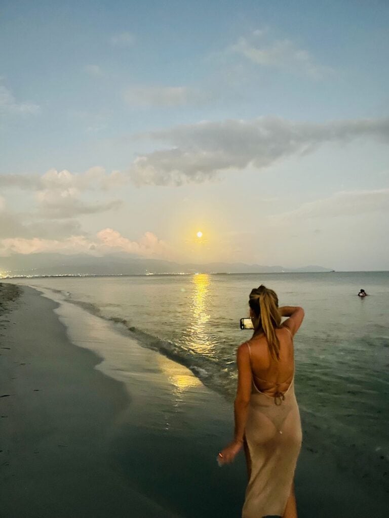 solo female traveler taking photos by the beach